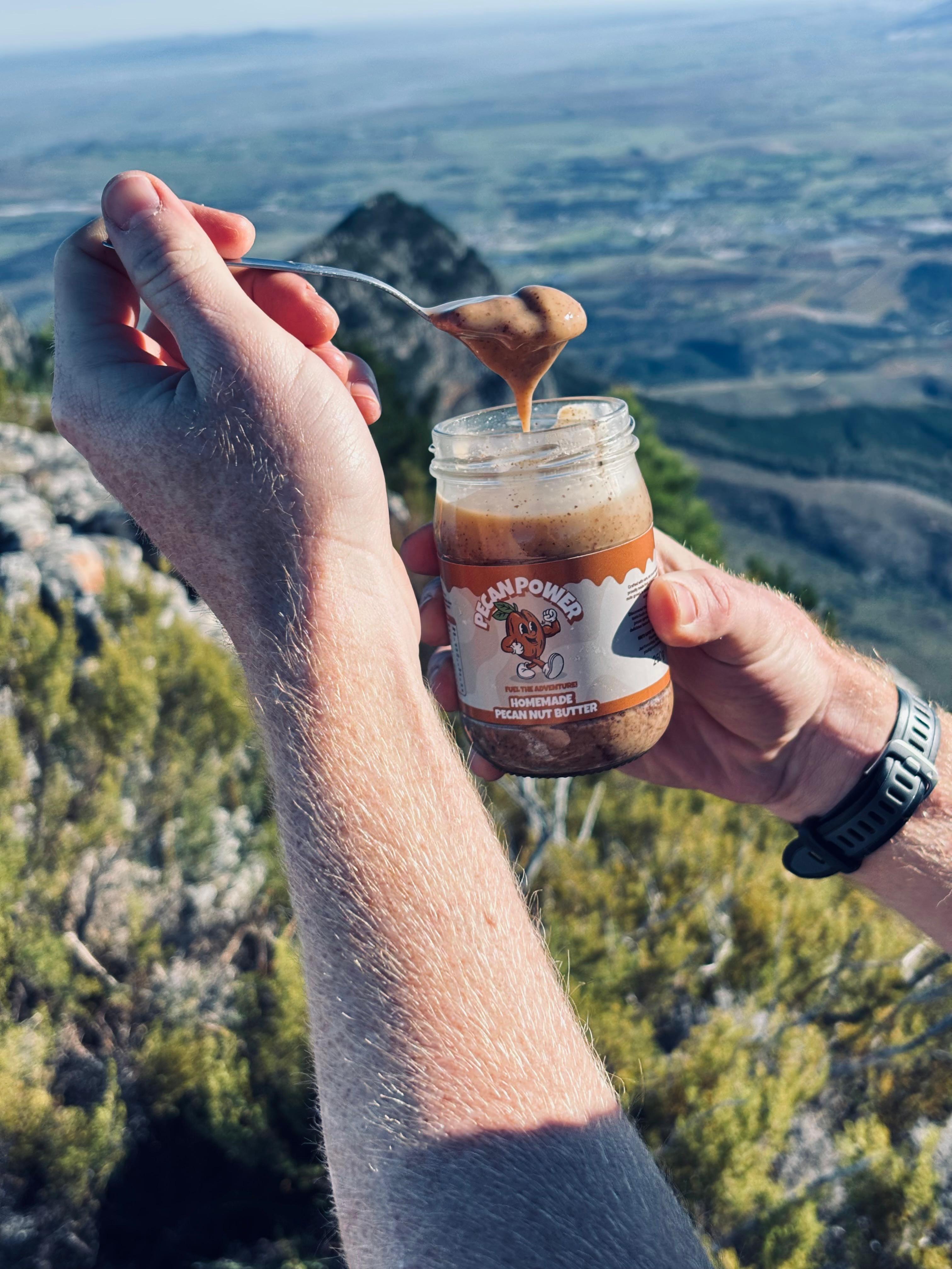 Pecan Power butter dripping from a spoon on a mountain top